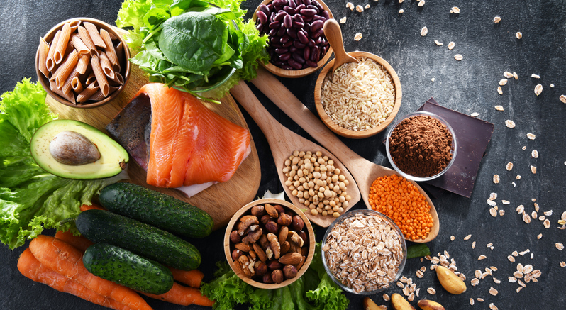 Fruits, vegetables, grains, salmon displayed on a table to show a healthy diet